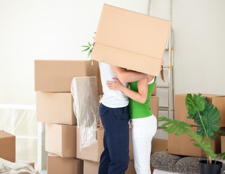Removal team carrying furniture through a narrow flat corridor in Poplar